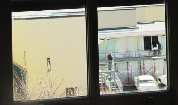 (Left) A view of Lorraine Hotel, from second floor bathroom window in the boarding house from where James Earl Ray was alleged to have fired the fatal shot at Martin Luther King, Jr. (Right) Boarding house view of Lorraine Motel balcony. Photo/Mr. Littlehand / Wikimedia Commons.