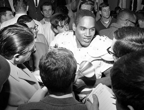 ** FILE** USC’s O. J. Simpson, who scored both his team’s touchdowns, is interviewed by the press after leading Trojans to 14-3 Rose Bowl win in 1968. Simpson, who gained 128 yards in 25 carries, was named Player of the Game. ( Don Cormier/ Los Angeles Times, CC BY-SA 4.0 via Wikimedia Commons)