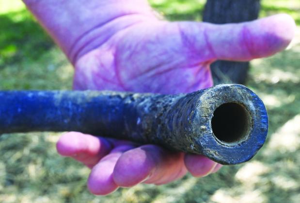 A piece of lead pipe removed from Jerry Land’s yard in Olathe shows a layer of lining inside the pipe that indicates the city’s water supply provided a thin film that prevented the pipe from leeching lead into the home’s water .photo(Carlos Moreno/KCUR).