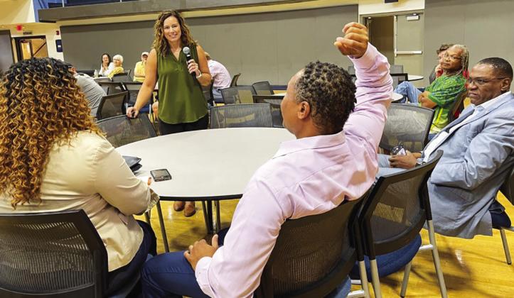 Tiffany (left) and Anwar (middle) Lee at an outreach event in St. Louis on June 22, 2023, where the state’s new chief equity officer, Abigail Vivas (in green), went through all the eligibility requirements for the cannabis microbusiness program Rebecca Rivas/Missouri Independent.
