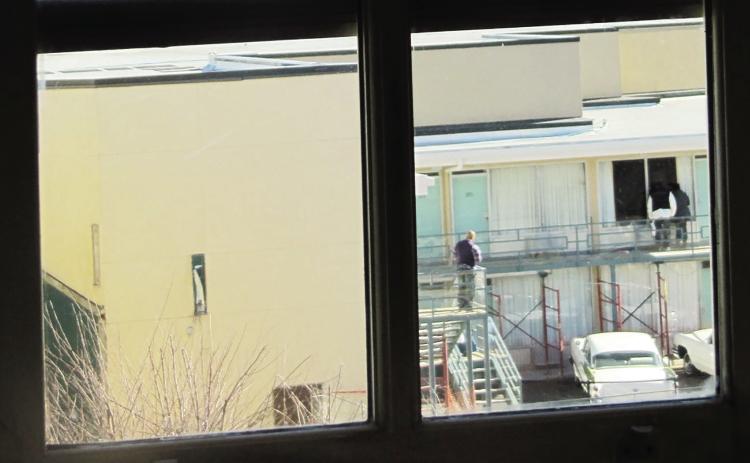 (Left) A view of Lorraine Hotel, from second floor bathroom window in the boarding house from where James Earl Ray was alleged to have fired the fatal shot at Martin Luther King, Jr. (Right) Boarding house view of Lorraine Motel balcony. Photo/Mr. Littlehand / Wikimedia Commons.