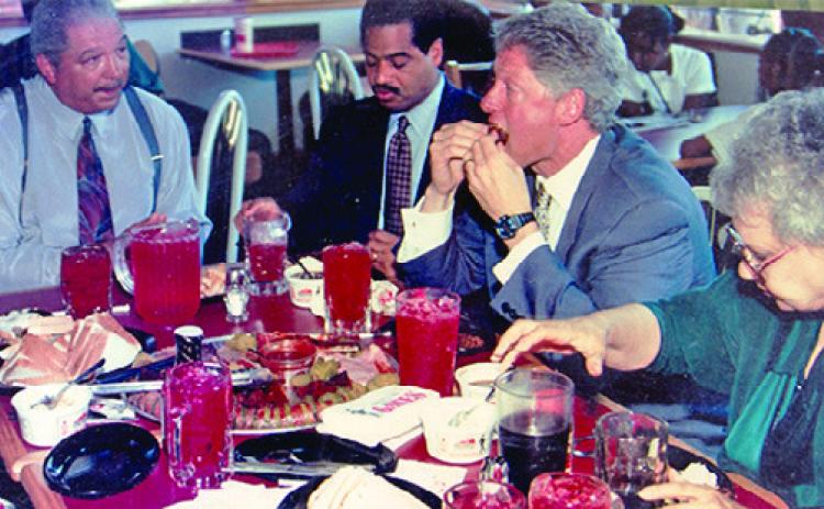 Throughout its 80-year history Gates Bar-B-Q has been a favorite of many national and world leaders and dignitaries. In this archive photo is then President Bill Clinton (second from right), Congressman Alan Wheat (second from left) and Ollie Gates (left). (Photo/gatesbbq.com)