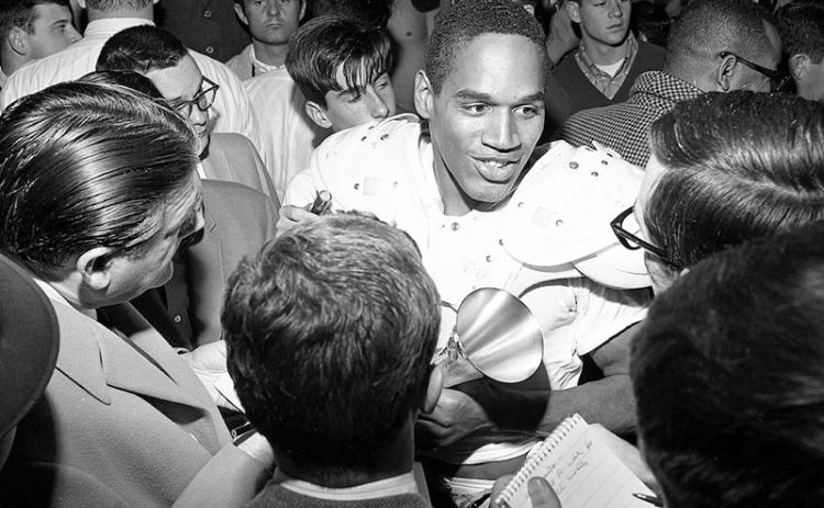 ** FILE** USC’s O. J. Simpson, who scored both his team’s touchdowns, is interviewed by the press after leading Trojans to 14-3 Rose Bowl win in 1968. Simpson, who gained 128 yards in 25 carries, was named Player of the Game. ( Don Cormier/ Los Angeles Times, CC BY-SA 4.0 via Wikimedia Commons)