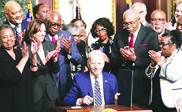 President Joe Biden signs a proclamation at the White House on July 25 designating a national monument spanning two states to memorialize Emmett Till and his mother, Mamie Till-Bradley. (photo courtesy of Mark Mahoney)-- RELATED STORY ON PAGE 8