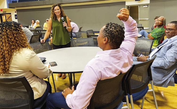 Tiffany (left) and Anwar (middle) Lee at an outreach event in St. Louis on June 22, 2023, where the state’s new chief equity officer, Abigail Vivas (in green), went through all the eligibility requirements for the cannabis microbusiness program Rebecca Rivas/Missouri Independent.
