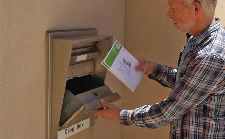 (Right) Greg Lange of Bismarck, North Dakota, drops off his absentee ballot and his wife’s at the Bismarck Burleigh County Office Building. (Photo by Michael Achterling/North Dakota Monitor)