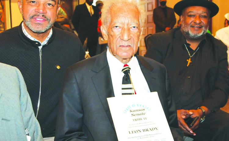 Leon Brady holds a Tribute presented to him by Kansas State Sen. David Haley (left) at his 90th birthday event at the Bruce R. Watkins Cultural Heritage Center and Museum. 2022 file photo/ courtesy Jerry Lockett